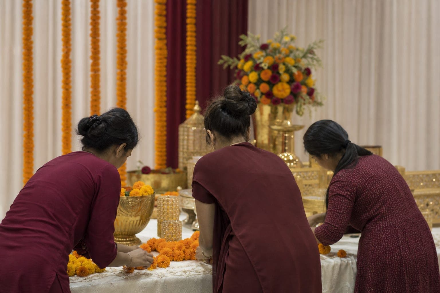 Indian event services team arranging marigold wedding decor