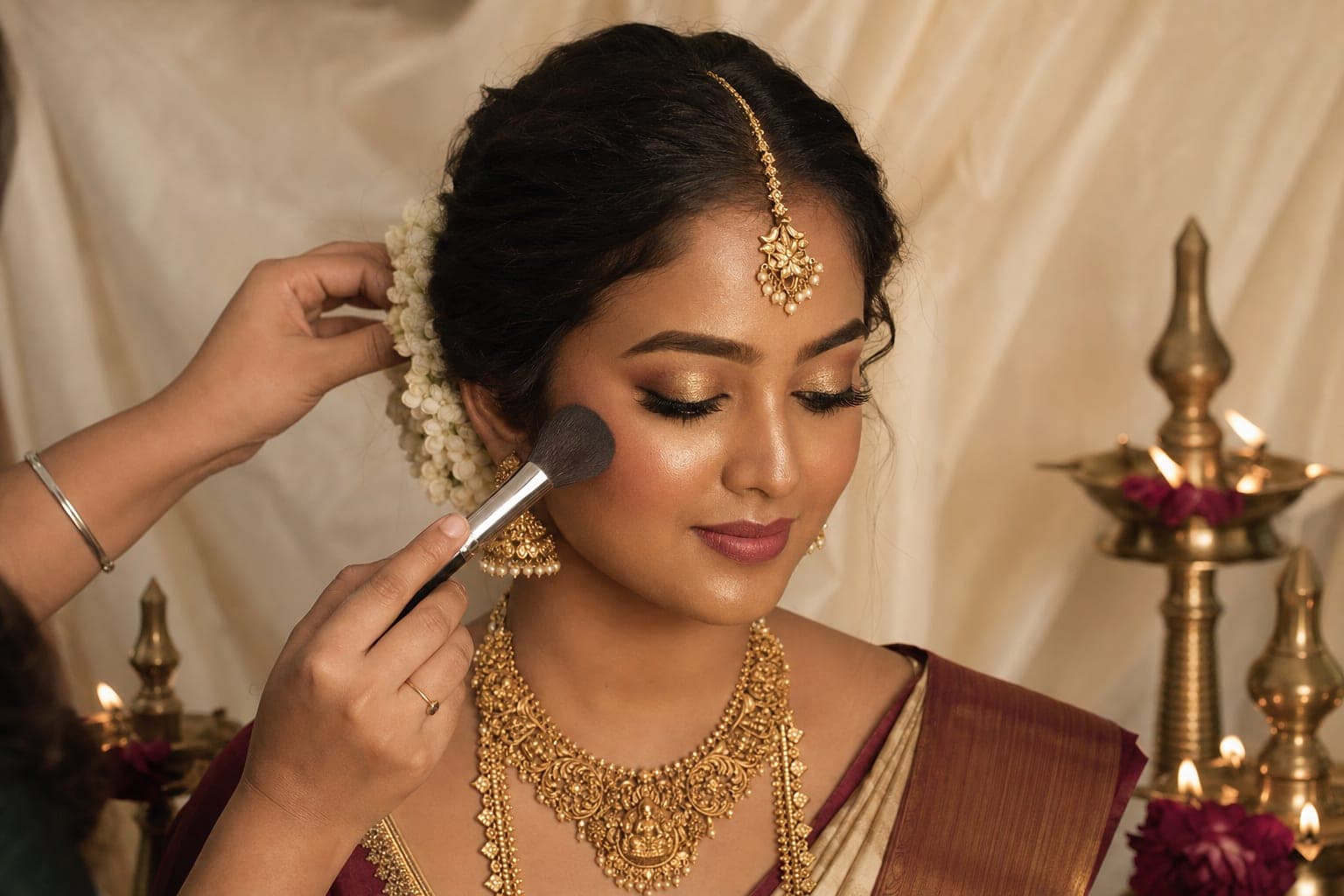 Indian bride receiving bridal makeup and hair styling